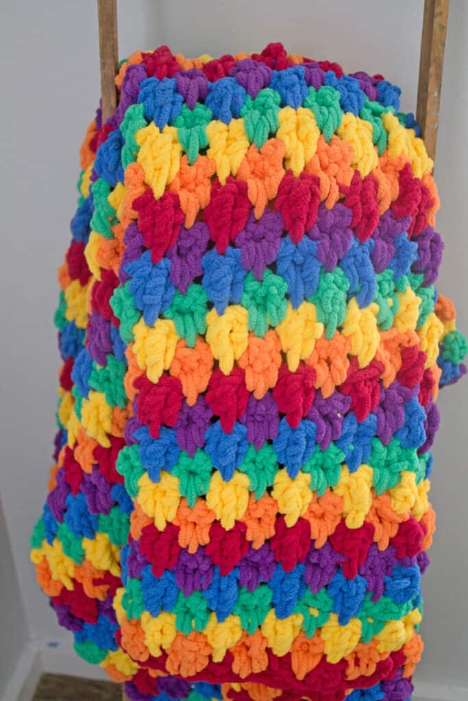 Make this colorful chunky rainbow teardrop crochet blanket free pattern. super bulky chenille yarn - amorecraftylife.com -bernat blanket yarn -lap afghan - free printable crochet pattern - bernat blanket yarn #crochet #crochetpattern #freecrochetpattern