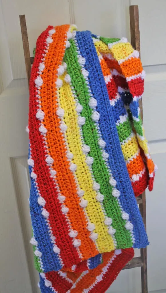 Try this colorful rainbow double dot crochet baby blanket pattern. This pattern uses basic stitches plus the bobble stitch for this pattern. Find the free PDF amorecraftylife.com