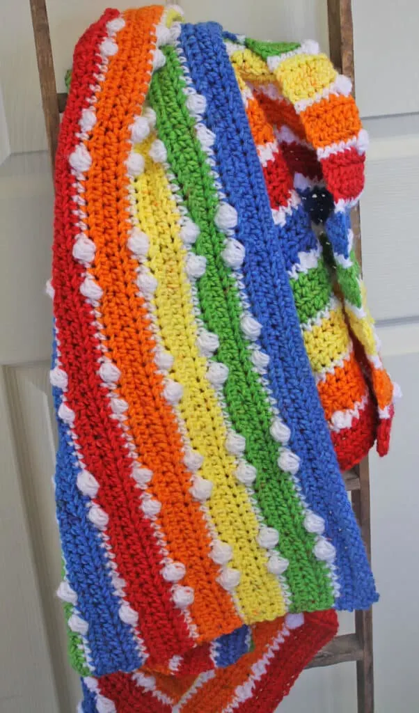 Try this colorful rainbow double dot crochet baby blanket pattern. This pattern uses basic stitches plus the bobble stitch for this pattern. Find the free PDF amorecraftylife.com