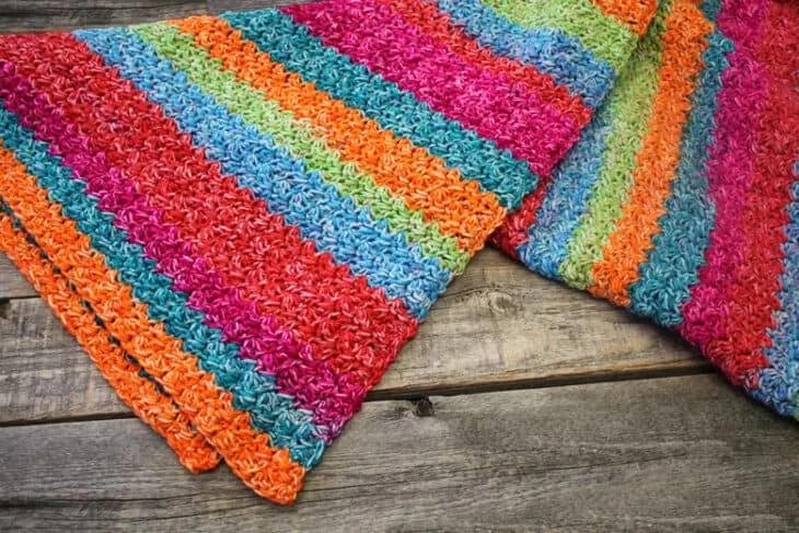 Try this easy Suzette Rainbow Baby Blanket Crochet Pattern. This colorful blanket has a simple 1 row repeat pattern using a self striping yarn. amorecraftylife.com