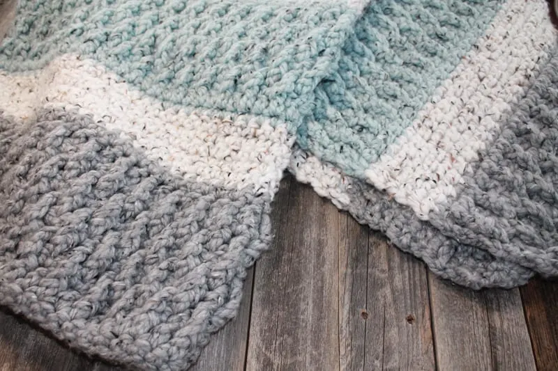 Try this super bulky tweed throw crochet pattern. This blanket uses the alpine stitch and single crochet to make a modern chunky blanket. There is a free printable PDF available.