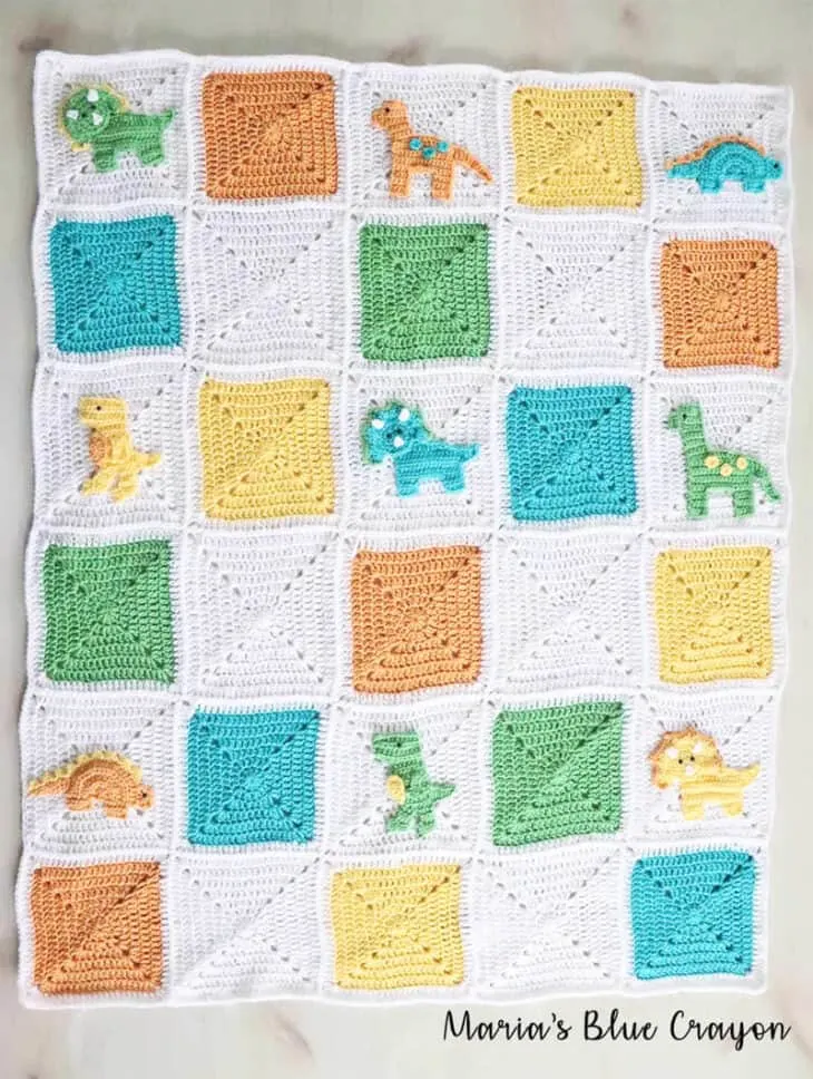 Make a cute crochet dinosaur blanket with this free pattern using granny squares and appliques. Crocheted dinosaur baby blanket in white, orange, yellow and green with 4 different dinosaur appliques.