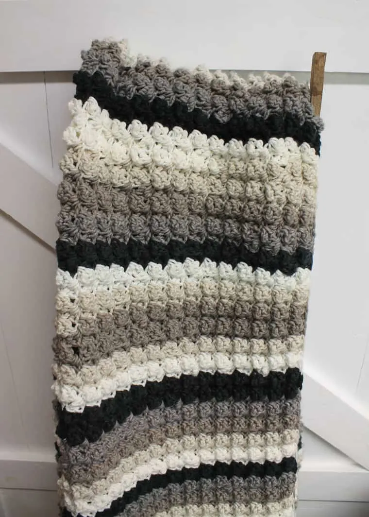 black, gray, and white striped crocheted blanket