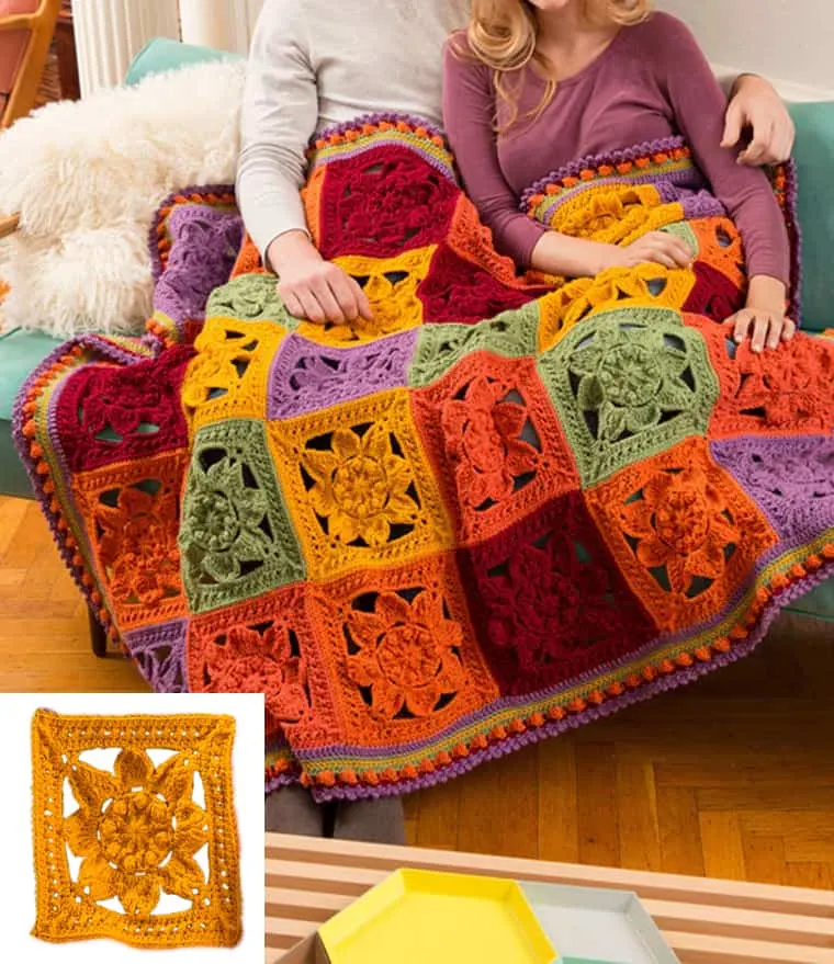 colorful crochet fall blanket out of different colored squares with a floral motif.
