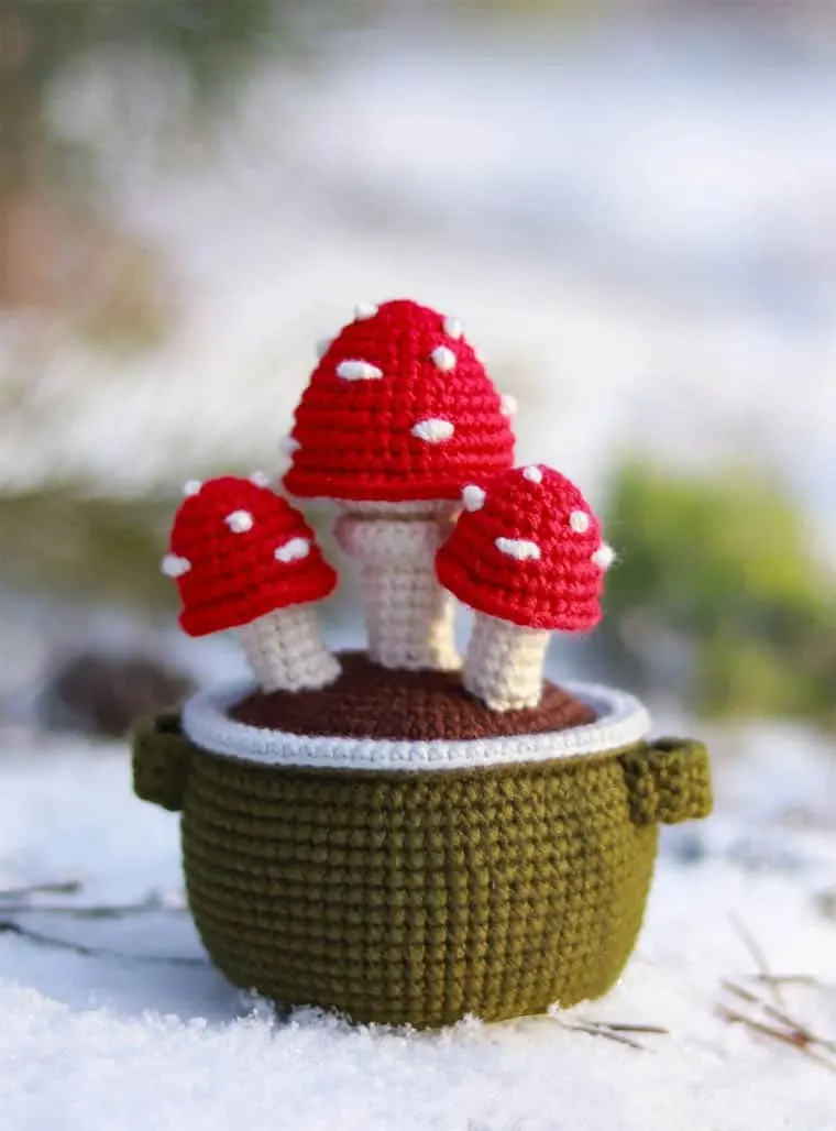 little group of crocheted mushrooms in a pot